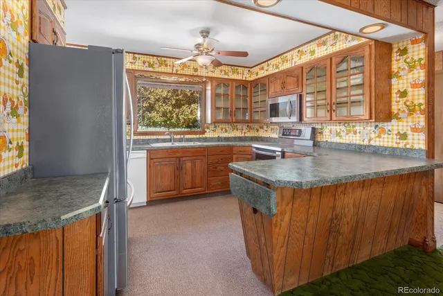 a view of a kitchen with kitchen island a sink and a large window