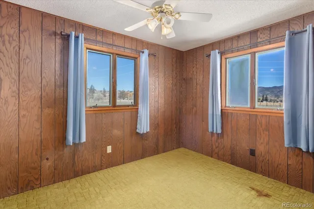 a view of a room with a chandelier fan