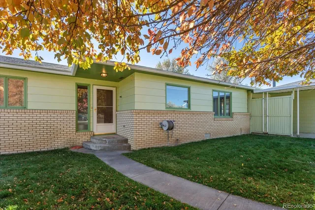 a view of a house with backyard and a tree