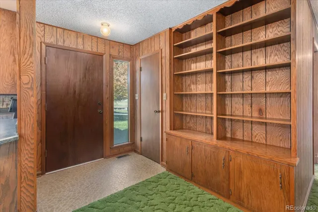 a view of a hallway with closet and wooden shelves