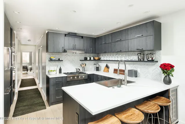 a kitchen with a sink a stove and chairs