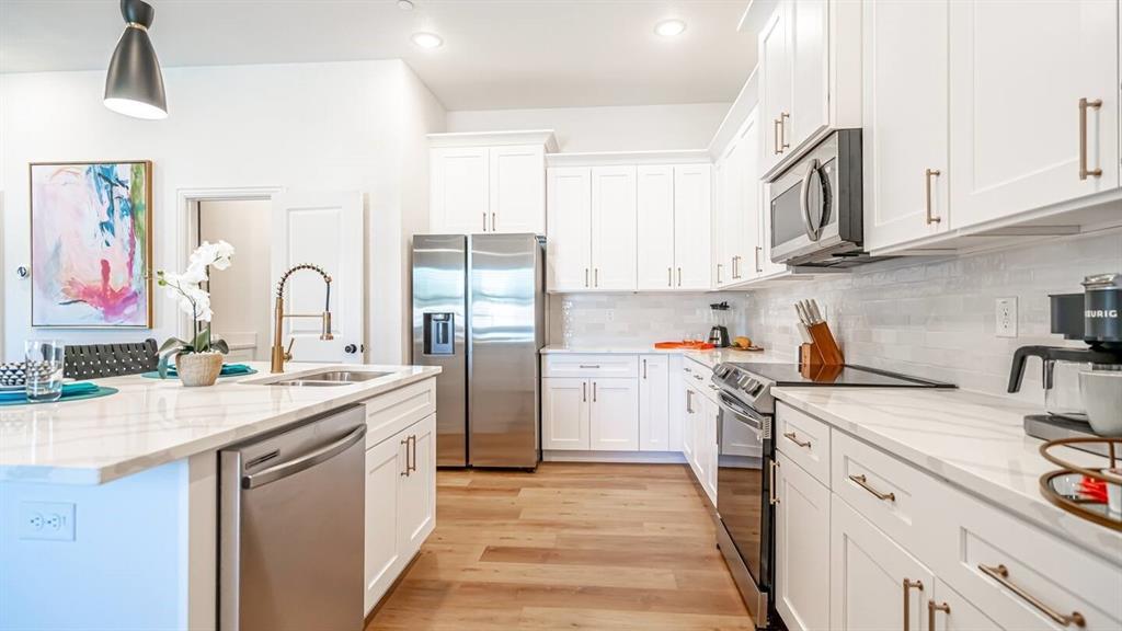 1215 Beaconsfield Lane, Unit 706 Arlington, TX 76011 - Photo 11 of 40 a kitchen with stainless steel appliances granite countertop a sink stove refrigerator and cabinets
