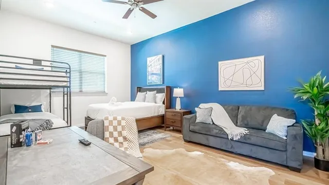 a spacious bedroom with a bed a couch and potted plant with view