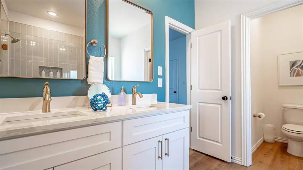 1215 Beaconsfield Lane, Unit 706 Arlington, TX 76011 - Photo 29 of 40 a bathroom with a sink a toilet and a mirror