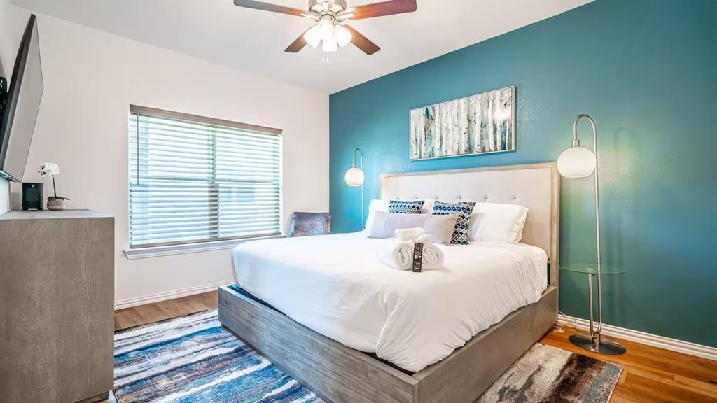 1215 Beaconsfield Lane, Unit 706 Arlington, TX 76011 - Photo 30 of 40 a bedroom with a bed and a chandelier