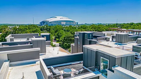 a view of a patio with table and chairs under an umbrella with a barbeque grill and wooden fence
