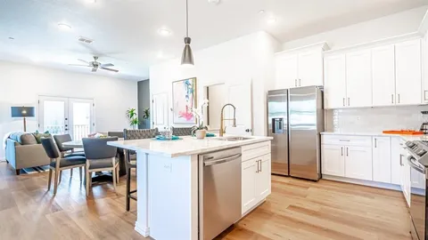 a kitchen with a table chairs refrigerator and cabinets