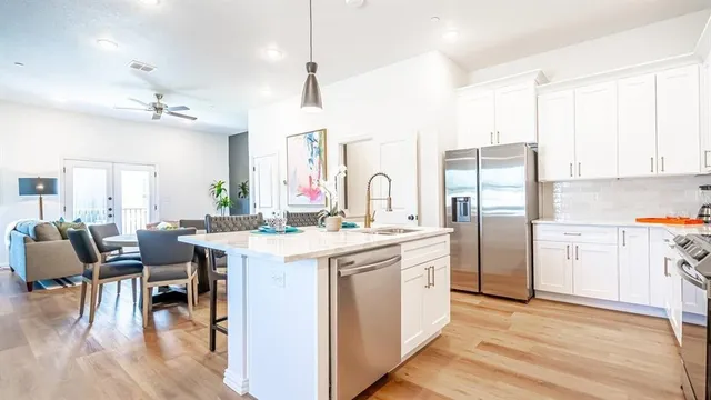 a kitchen with a table chairs refrigerator and cabinets