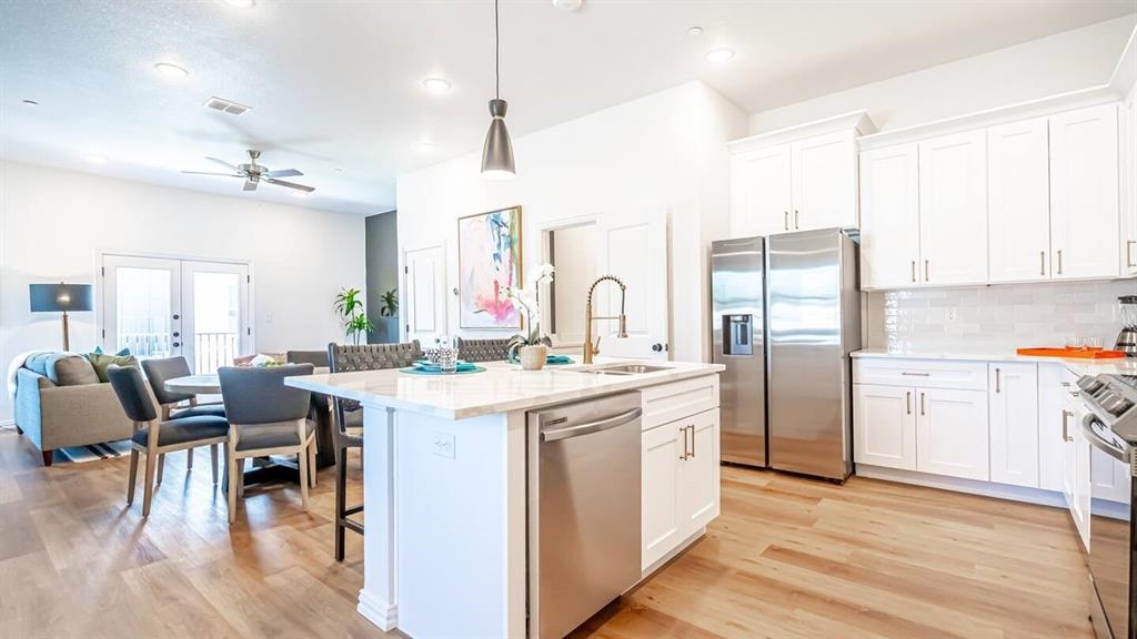 1215 Beaconsfield Lane, Unit 706 Arlington, TX 76011 - Photo 9 of 40 a kitchen with a table chairs refrigerator and cabinets