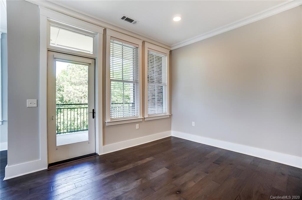 830 Providence Road, Unit 303 Charlotte, NC 28207 - Photo 14 of 39 a view of an empty room with wooden floor and a window