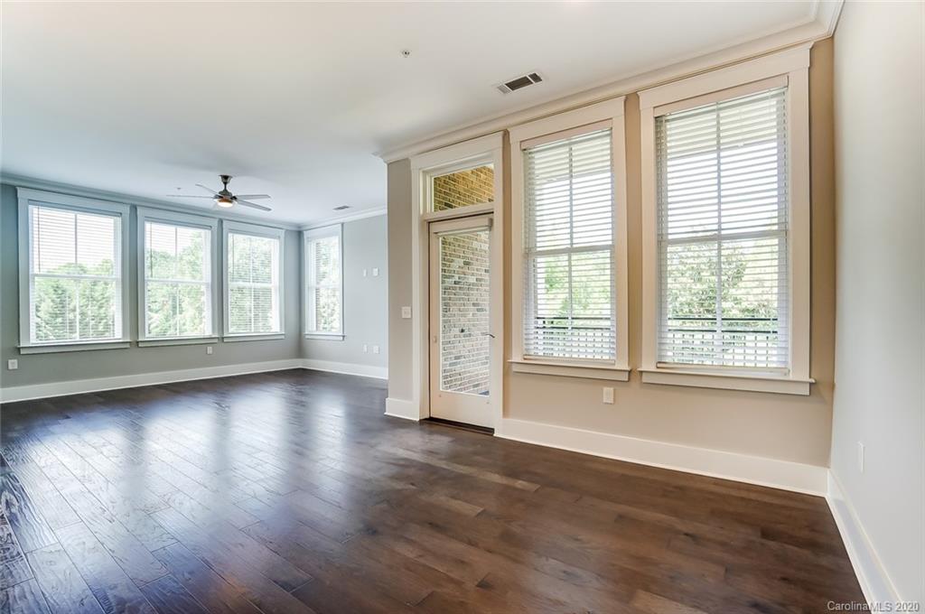 830 Providence Road, Unit 303 Charlotte, NC 28207 - Photo 17 of 39 a view of an empty room with wooden floor and a window