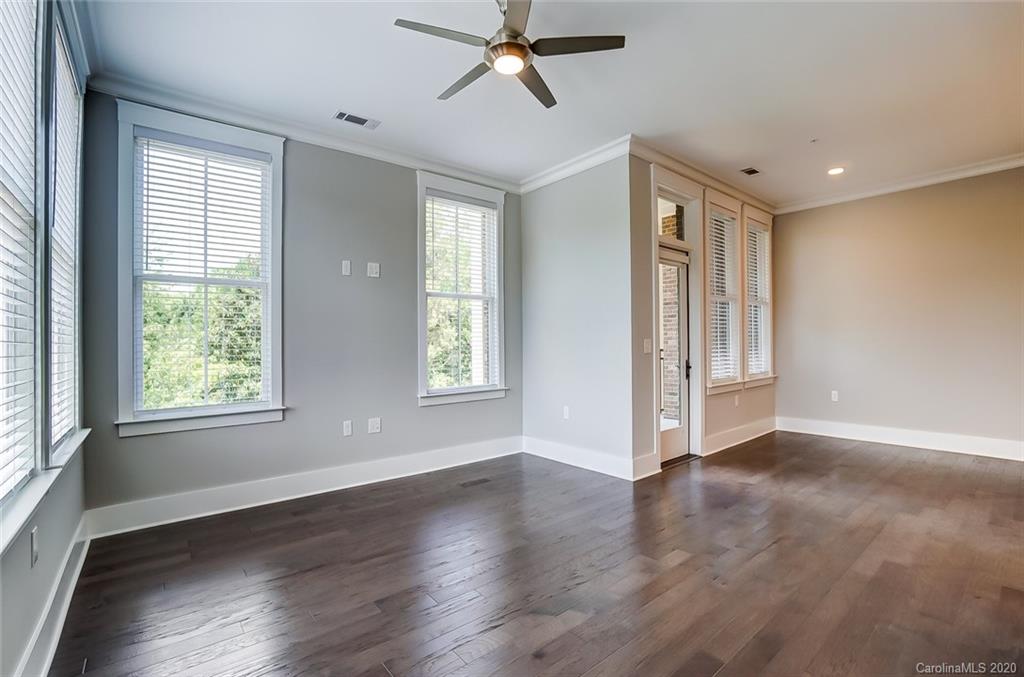 830 Providence Road, Unit 303 Charlotte, NC 28207 - Photo 18 of 39 a view of an empty room with a window and wooden floor