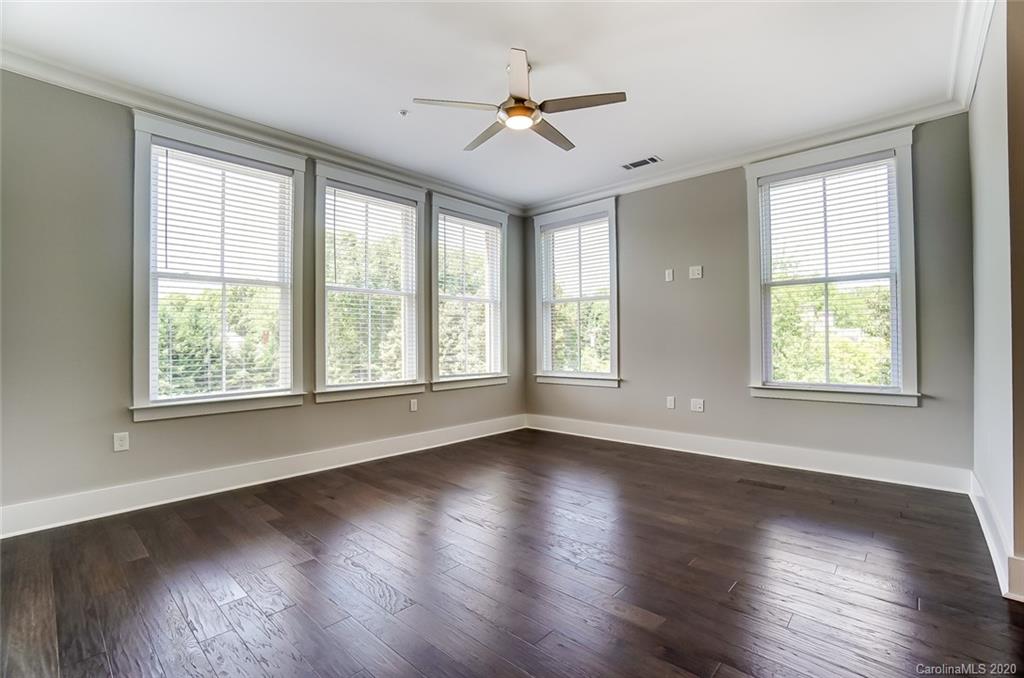 830 Providence Road, Unit 303 Charlotte, NC 28207 - Photo 19 of 39 a view of an empty room with wooden floor and a window
