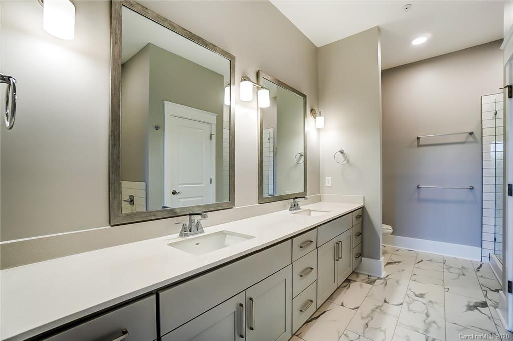 830 Providence Road, Unit 303 Charlotte, NC 28207 - Photo 25 of 39 a bathroom with a sink double vanity and a mirror