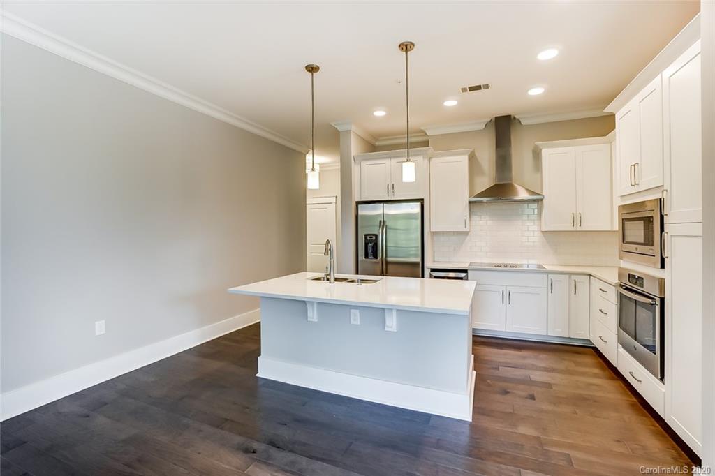 830 Providence Road, Unit 303 Charlotte, NC 28207 - Photo 5 of 39 a large kitchen with granite countertop a sink a counter space appliances and cabinets
