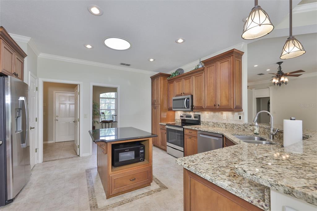 1107 Opal Lane Sun City Center, FL 33573 - Photo 16 of 72 a kitchen with stainless steel appliances granite countertop a sink stove and refrigerator