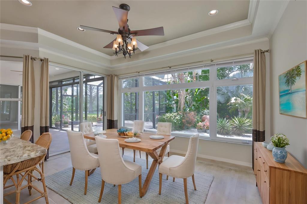 1107 Opal Lane Sun City Center, FL 33573 - Photo 20 of 72 a view of a dining room with furniture large windows and wooden floor