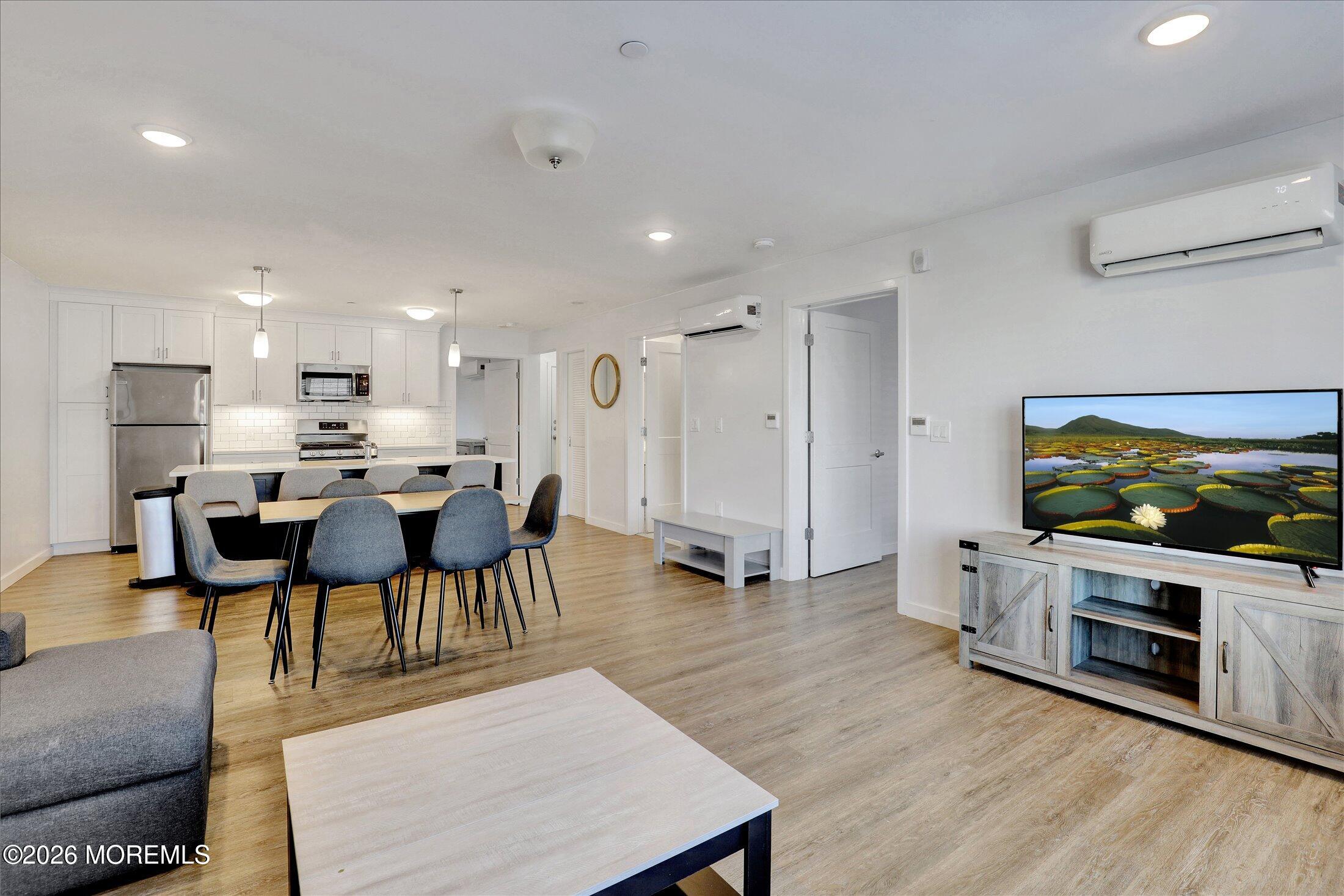 55 Brighton Avenue, Unit 2 Long Branch, NJ 07740 - Photo 19 of 36 a living room with stainless steel appliances furniture a fireplace a flat screen tv and view kitchen