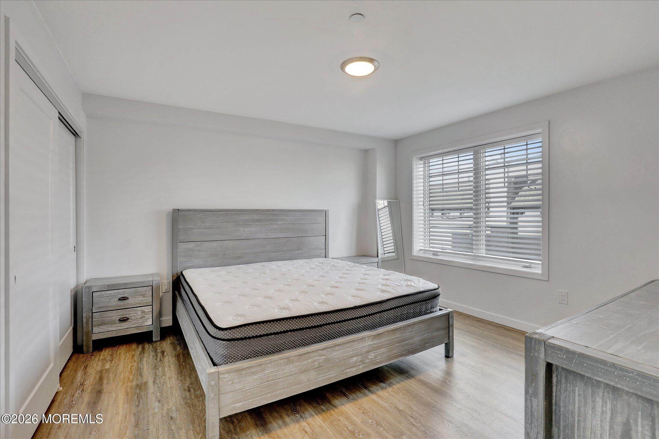 55 Brighton Avenue, Unit 2 Long Branch, NJ 07740 - Photo 20 of 36 a bed sitting in a bedroom next to a window