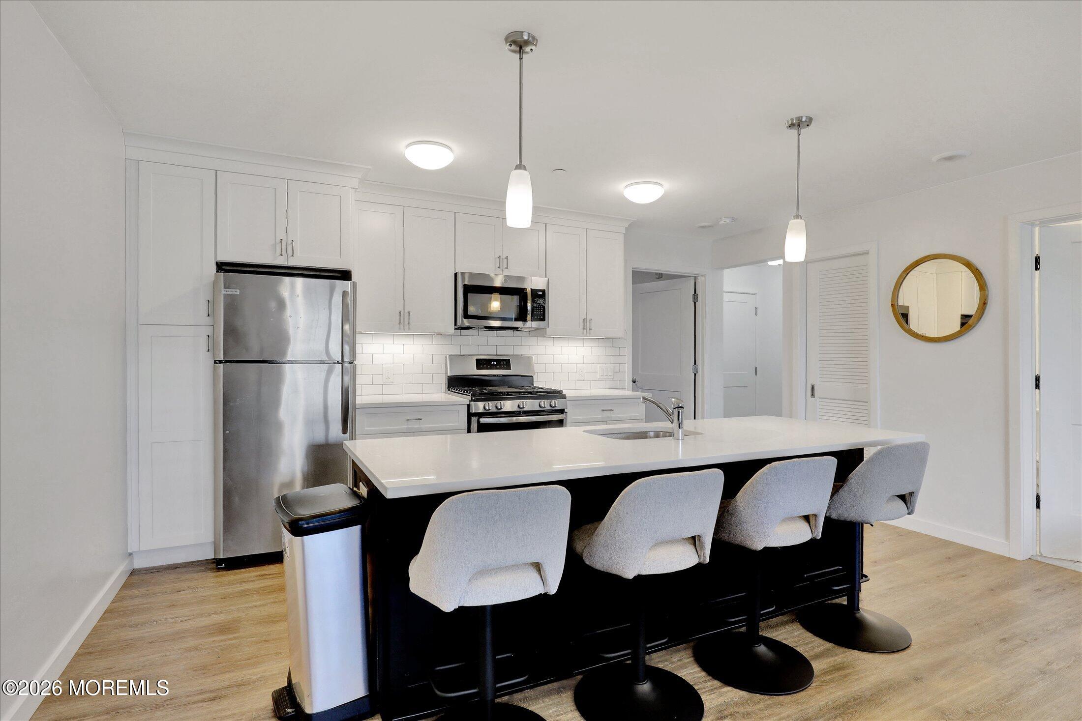 55 Brighton Avenue, Unit 2 Long Branch, NJ 07740 - Photo 10 of 36 a kitchen with refrigerator and chairs