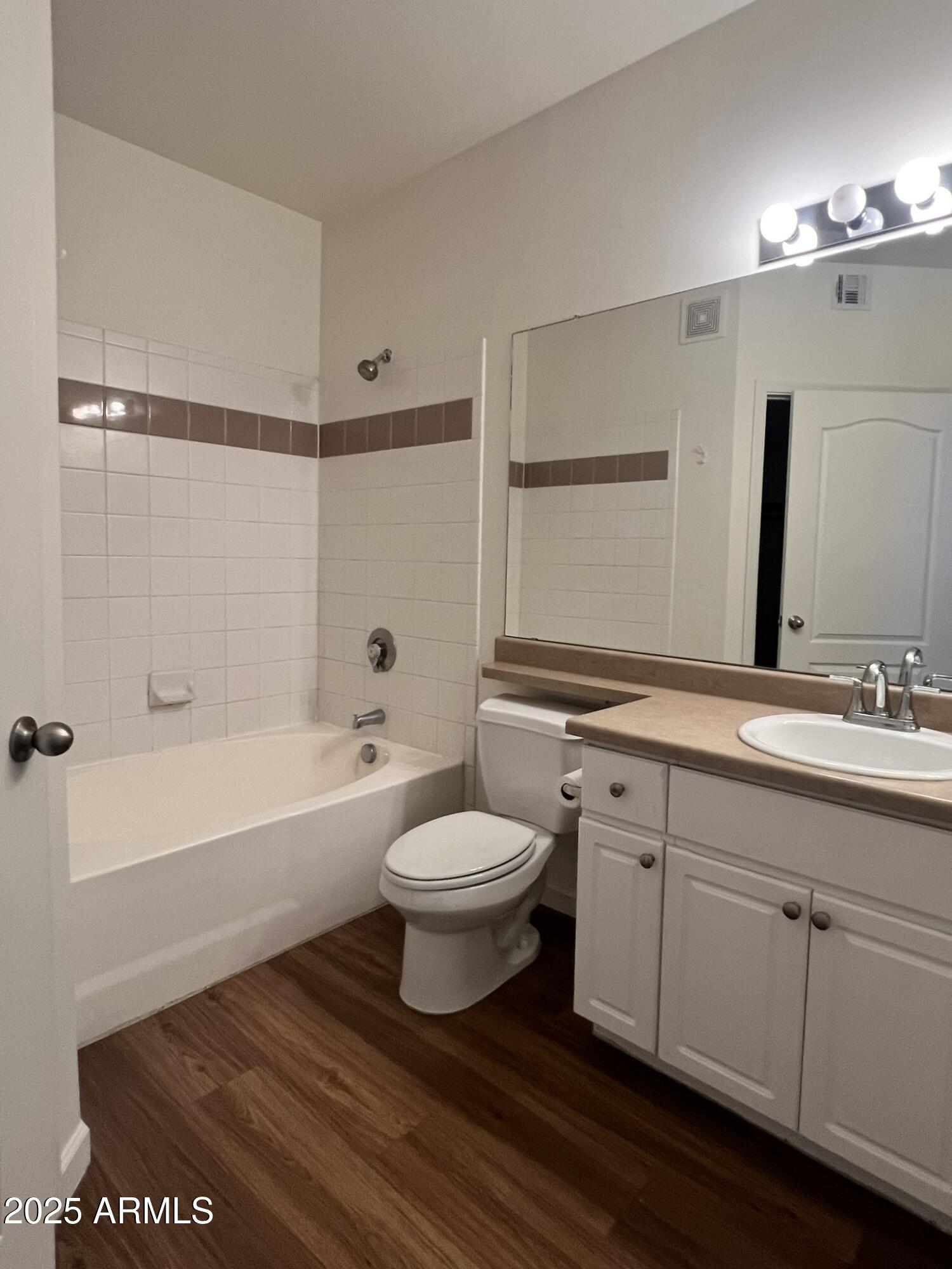 1701 East Colter Street, Unit 253 Phoenix, AZ 85016 - Photo 14 of 17 a bathroom with a toilet a sink a mirror a bathtub and vanity