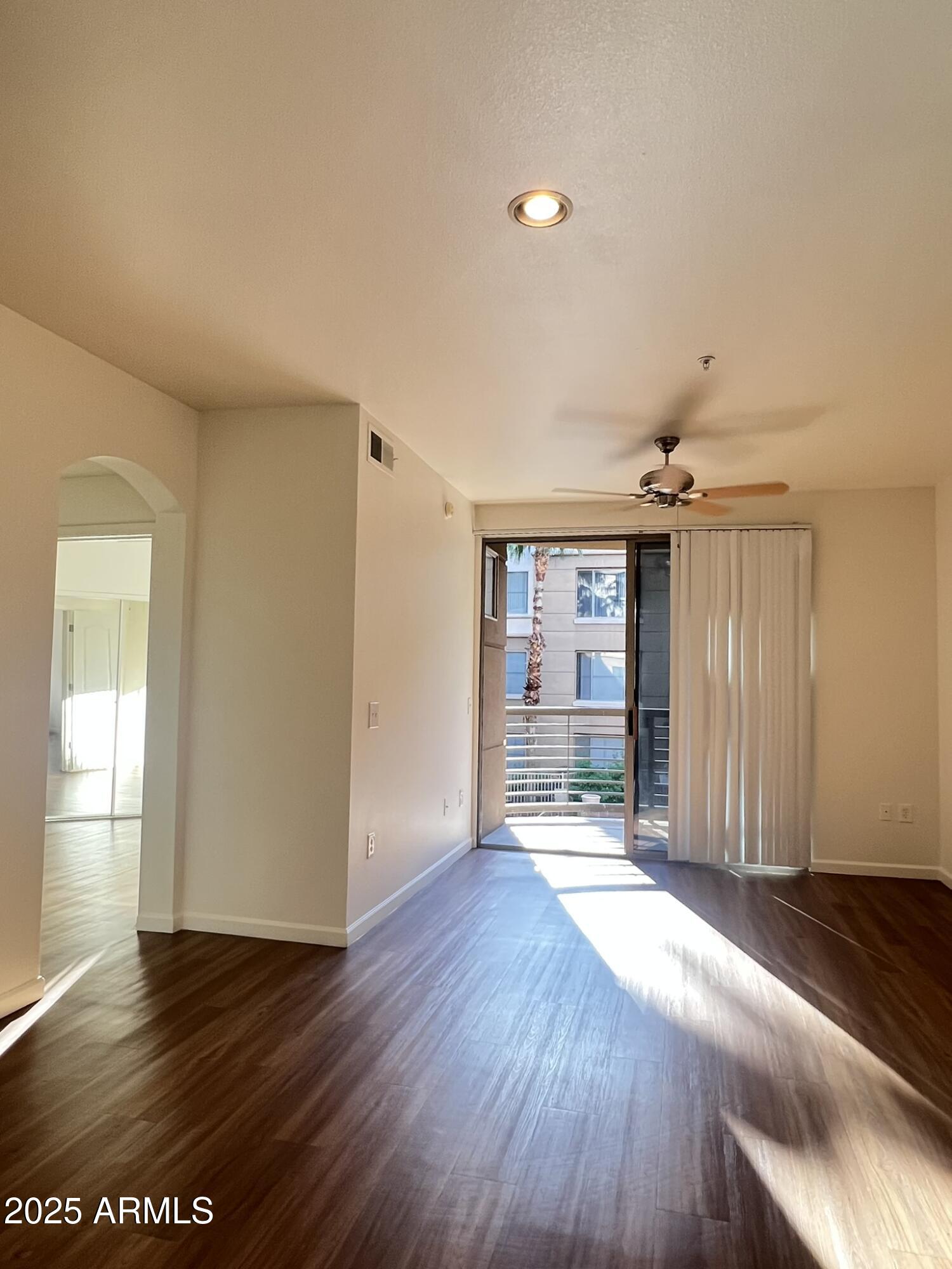 1701 East Colter Street, Unit 253 Phoenix, AZ 85016 - Photo 4 of 17 an empty room with wooden floor and windows