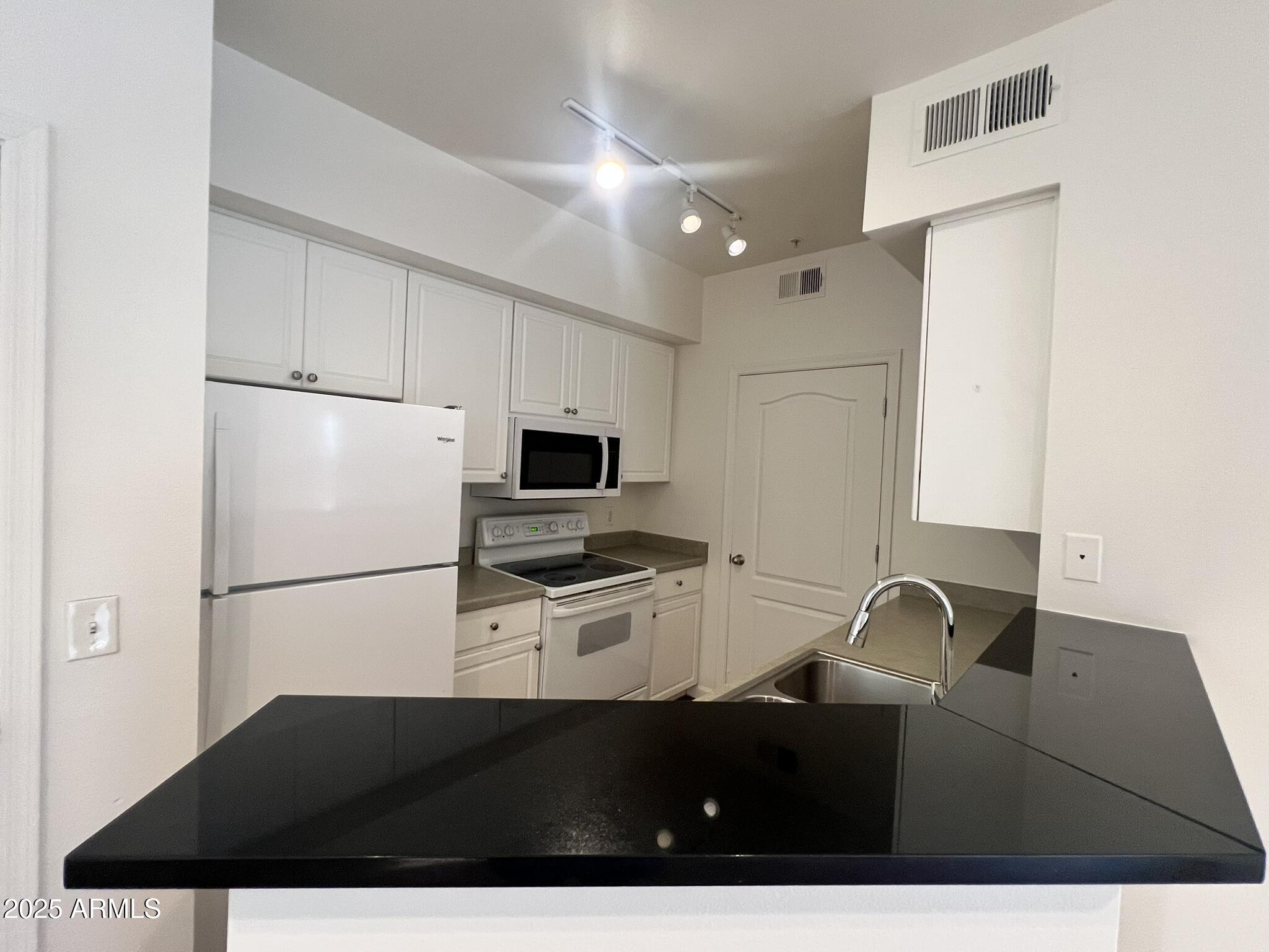 1701 East Colter Street, Unit 253 Phoenix, AZ 85016 - Photo 8 of 17 a kitchen with a refrigerator and a stove top oven