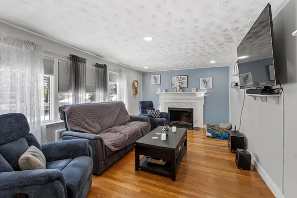 a living room with furniture a large window and a fireplace