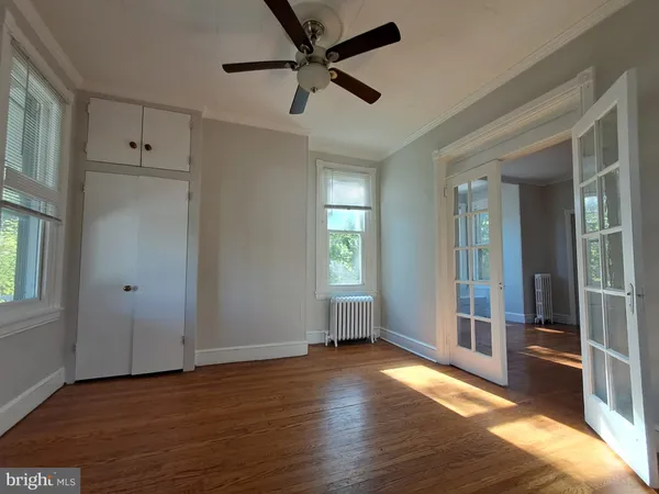 a view of an empty room with wooden floor and a fireplace