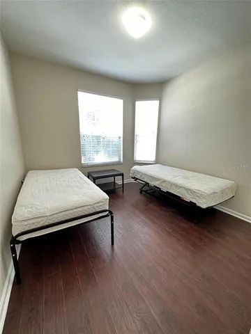 a bedroom with two beds and wooden floor