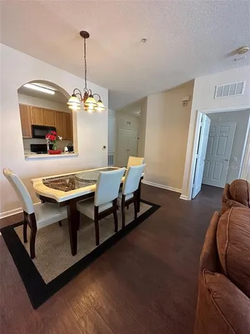 a view of a dining room with furniture wooden floor and chandelier