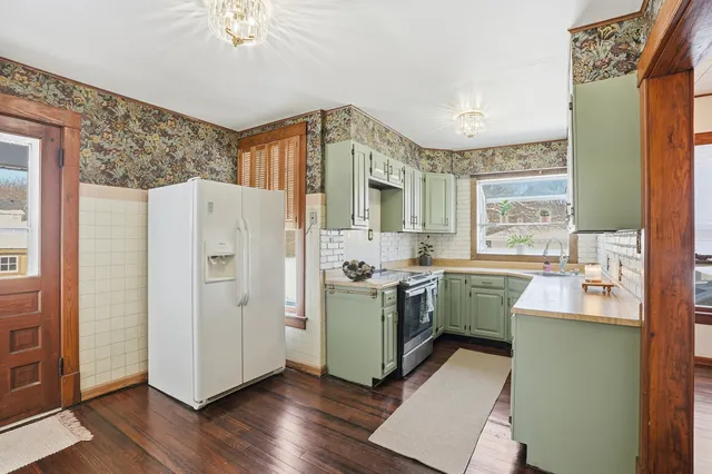 a kitchen with stainless steel appliances granite countertop a refrigerator a sink dishwasher and a stove with wooden floor