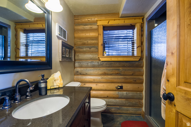 18906 North Canyon Road Whiterocks, UT 84085 - Photo 26 of 65 Bathroom featuring log walls, vanity, and a textured ceiling