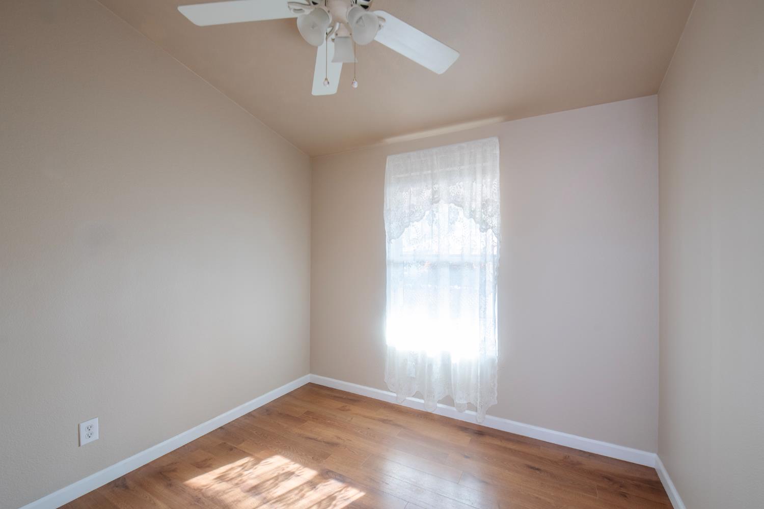 33751 Powerhouse Road, Unit 21 Auberry, CA 93602 - Photo 17 of 29 an empty room with a window and a chandelier fan