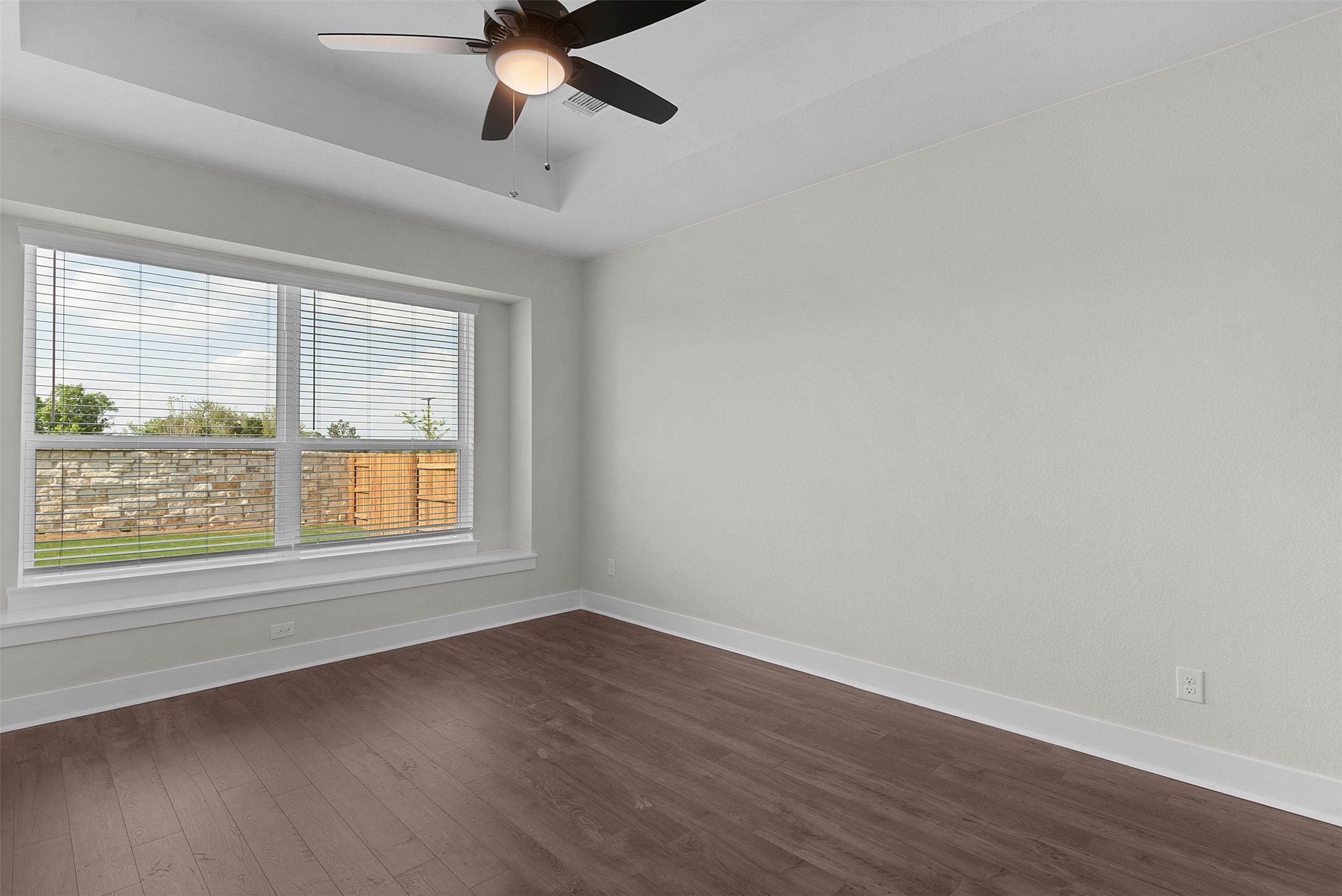 1121 Pansy Trail Georgetown, TX 78628 - Photo 12 of 25 Empty room featuring a raised ceiling, dark wood finished floors, and a ceiling fan