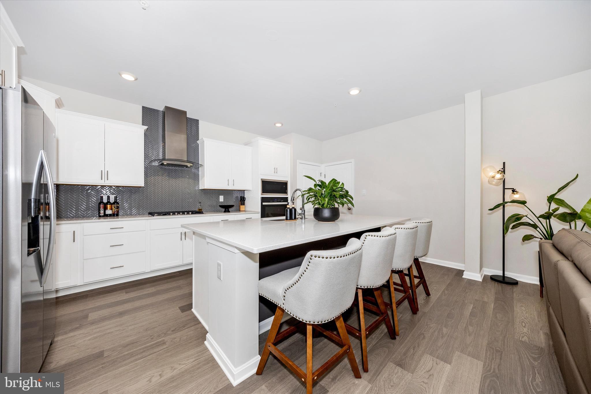 700 Bond Street Frederick, MD 21701 - Photo 12 of 49 a kitchen with stainless steel appliances white cabinets and wooden floor