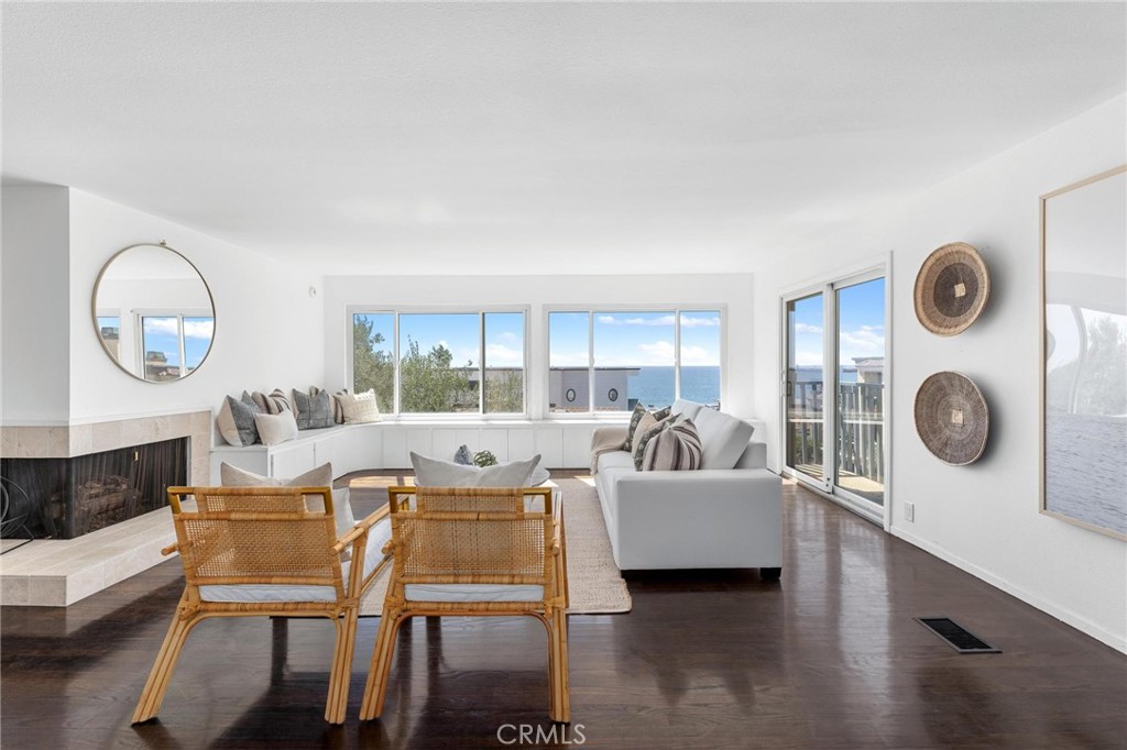 224 18th Street Manhattan Beach, CA 90266 - Photo 9 of 63 a living room with couches a fireplace and a large mirror with wooden floor