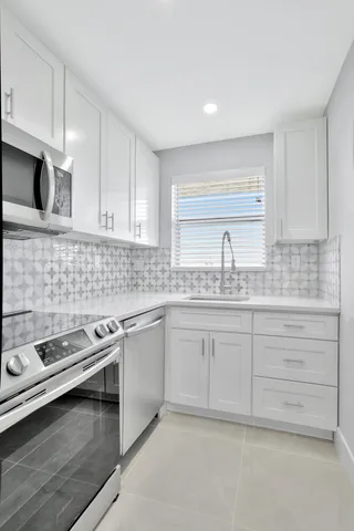 a kitchen with granite countertop white cabinets and white appliances