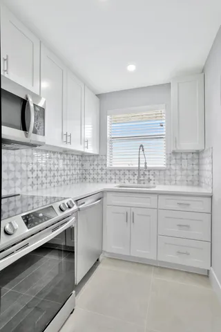 a kitchen with granite countertop white cabinets and white appliances