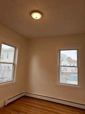 a view of an empty room with wooden floor
