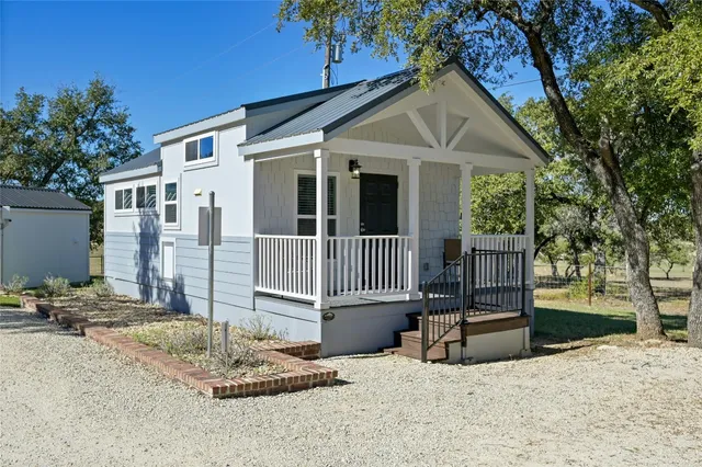 a view of a house with a small yard and wooden fence