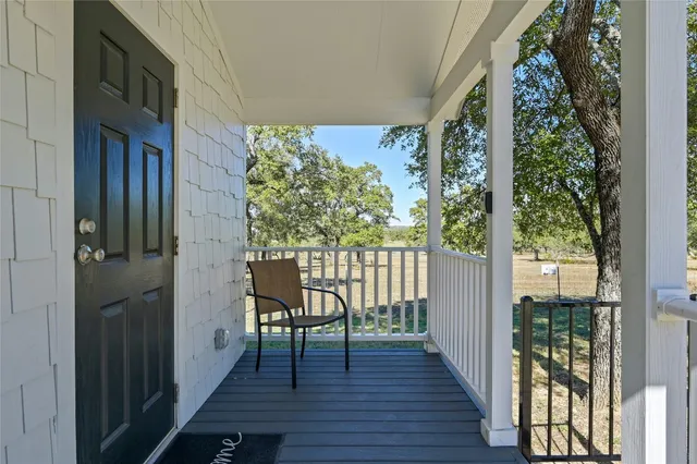 a view of a balcony with wooden floor and furniture