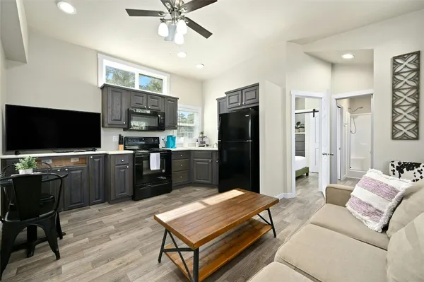 a kitchen with stainless steel appliances kitchen island granite countertop a refrigerator a stove top oven a sink dishwasher and wooden cabinets