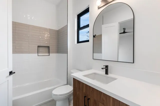 a bathroom with a sink a toilet and a mirror