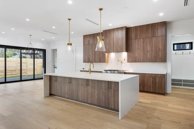 a large kitchen with kitchen island a sink stainless steel appliances and cabinets