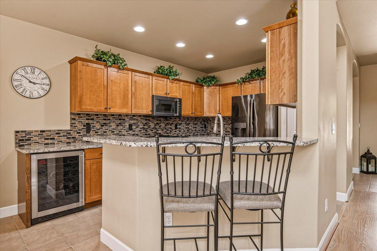 1339 Southwest Rimrock Way Redmond, OR 97756 - Photo 5 of 26 a kitchen with stainless steel appliances a stove a sink and a refrigerator
