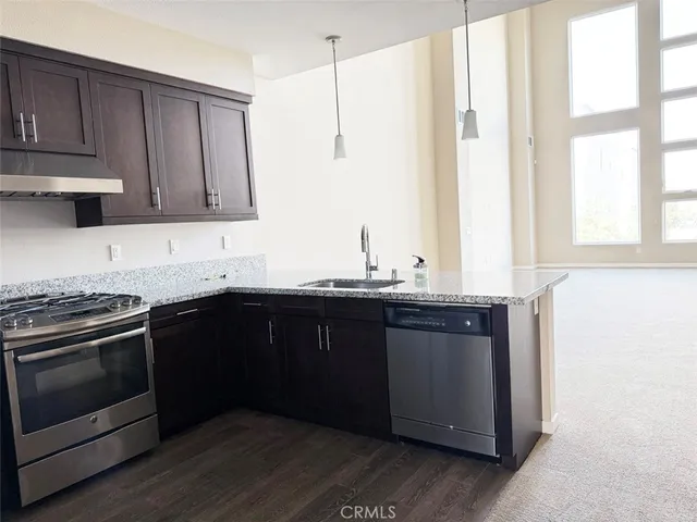 a kitchen with stainless steel appliances granite countertop a stove a sink and a microwave