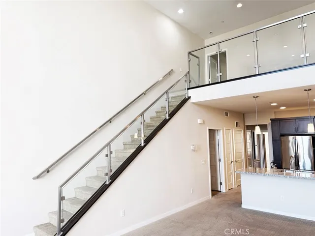 a view of staircase with lots of frames on wall and windows