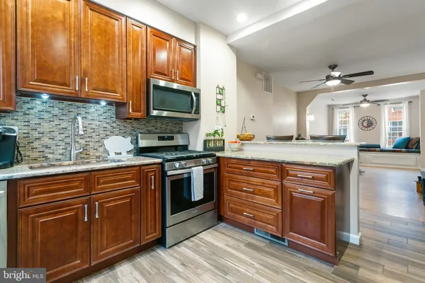 a kitchen with stainless steel appliances granite countertop a refrigerator and a sink