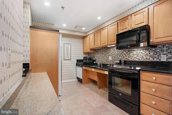 a kitchen with stainless steel appliances granite countertop a stove microwave and sink